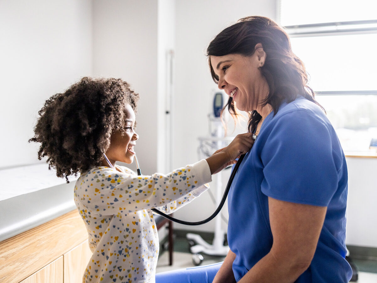 Young girl listening to nurses heart with stethoscope